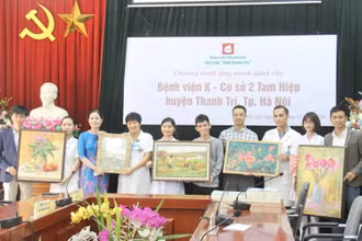 Họa sĩ Nguyễn Thị Kim Đức (thứ ba từ trái sang) trao tặng bộ tranh cho Bệnh viện K cơ sở 2. (Ảnh: Nguyễn Hoàng)