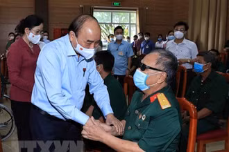 Chủ tịch nước Nguyễn Xuân Phúc đến thăm hỏi, tặng quà các thương bệnh binh tại Trung tâm Nuôi dưỡng thương bệnh binh nặng và điều dưỡng người có công tỉnh Hà Nam. (Ảnh: TTXVN)
