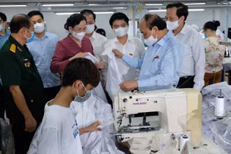 Ngày 23/7, Chủ tịch nước Nguyễn Xuân Phúc đến thăm doanh nghiệp may mặc Hoàng Tuyên tại tỉnh Hà Nam, do thương binh làm kinh tế giỏi Hoàng Văn Tuyên làm chủ. (Ảnh: Đào Phương)