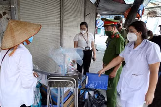 Lực lượng chức năng phường Đồng Xuân, quận Hoàn Kiếm phát hiện, lập biên bản xử lý một trường hợp bán rong khẩu trang không rõ nguồn gốc, vi phạm quy định phòng, chống dịch. (Ảnh: TTXVN)