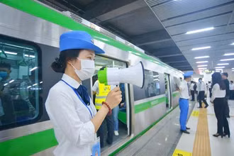 Nhân viên tàu điện Cát Linh-Hà Đông hướng dẫn hành khách mua vé và bảo đảm trật tự trước khi lên tàu.