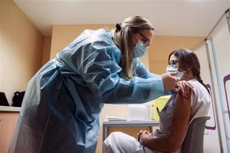 Nhân viên y tế tiêm vaccine ngừa COVID-19 tại Liege (Bỉ). (Ảnh: AFP/TTXVN)