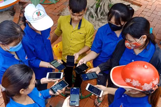 Thanh niên tình nguyện và người dân cùng cài đặt ứng dụng Bluezone ở Gia Lai.
