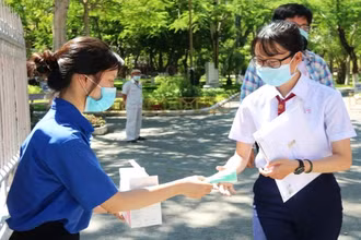 Thanh niên tình nguyện phát khẩu trang cho thí sinh ngay tại cổng vào các điểm thi.