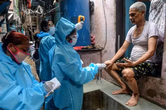 Nhân viên y tế đo thân nhiệt của người dân sống trong khu ổ chuột Dharavi, tại Mumbai. (Ảnh: Getty Images)
