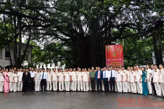Các đại biểu dự chương trình chụp ảnh lưu niệm dưới gốc đa Báo Nhân Dân.
