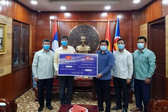 Đồng chí Bouahong Khamha (phải) trao 150 triệu kíp Lào để ủng hộ, đóng góp vào Quỹ vaccine phòng, chống Covid-19, ngày 12-6.