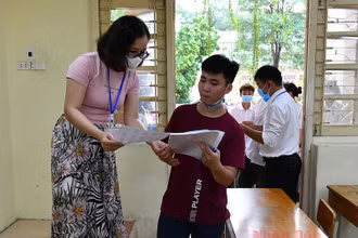 Cán bộ coi thi kiểm tra thông tin thí sinh tại Kỳ thi tốt nghiệp THPT 2020. ẢNh: THUỶ NGUYÊN