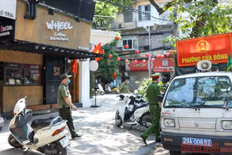 Công an phường Cửa Đông tuyên truyền nhắc nhở người dân phòng chống dịch. Ảnh: DUY LINH