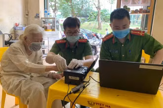 Các đồng chí trong tổ cấp CCCD, Công an quận Ba Đình, thực hiện lấy dấu vân tay tại nhà cho cụ Phạm Thị Mỹ.