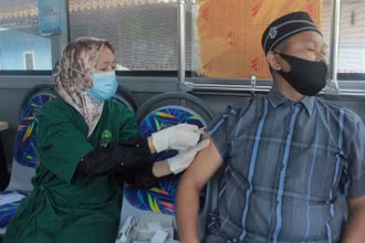 Tiêm vaccine ngừa Covid-19 bên trong “xe bus tiêm chủng” tại tỉnh Riau, Indonesia. (Ảnh: Reuters)
