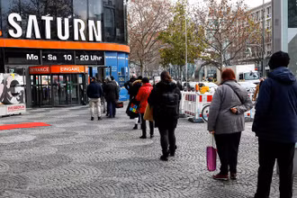 Người mua sắm xếp hàng trước cửa hàng điện tử Saturn trên đại lộ Tauentzienstrasse ở Berlin, Đức, ngày 14/12/2020. (Ảnh: Reuters)