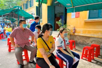 Phụ huynh và trẻ chờ đến lượt tiêm tại điểm trường THCS Hồng Bàng.