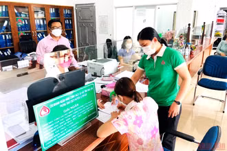 Cán bộ Phòng giao dịch Ngân hàng Chính sách-xã hội huyện Cư M’gar hướng dẫn người lao động làm thủ tục vay vốn ưu đãi theo Nghị quyết 11.