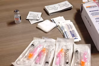 Lọ vaccine Covid-19 của Moderna bên cạnh kim tiêm và băng gạc. Ảnh: Getty Images.