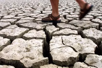 Một người đàn ông đi bộ qua hồ Jato khô cạn ở Italy. Ảnh: Reuters.