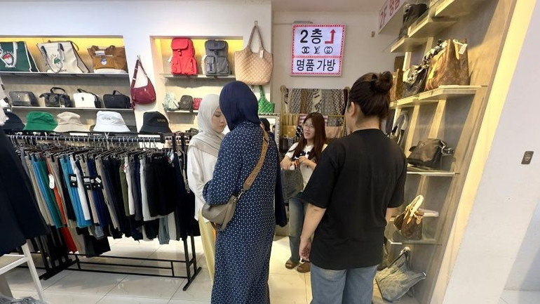 Nhân viên tư vấn cho khách du lịch mua túi hàng "fake" tại một cửa hàng đường Hùng Vương. z6929535061235-f972608a54fce7c323654149e7d74221.jpg