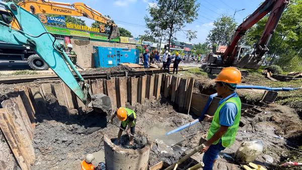 Công nhân kỹ thuật xử lý sự cố bể đường ống cấp nước tại tuyến đường Phạm Văn Đồng.