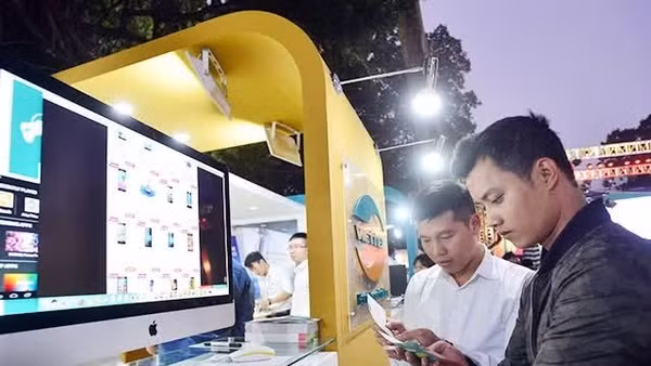 Khách hàng tìm hiểu thông tin sản phẩm tại ngày hội mua sắm trực tuyến Online Friday. (Ảnh: MINH HÀ)