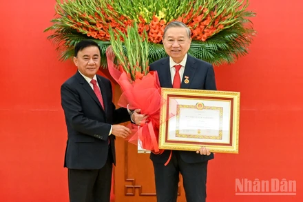 Thường trực Ban Bí thư Trần Cẩm Tú trao huy hiệu 45 năm tuổi đảng, tặng hoa chúc mừng đồng chí Tô Lâm, Tổng Bí thư Ban Chấp hành Trung ương Đảng Cộng sản Việt Nam. (Ảnh: DUY LINH)