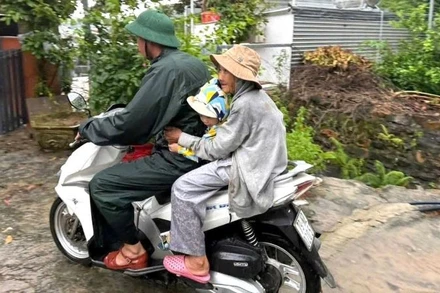 Chiến sĩ Đồn Biên phòng cửa khẩu cảng Nha Trang cơ động đưa người dân đến nơi an toàn. (Ảnh: Văn Tân).