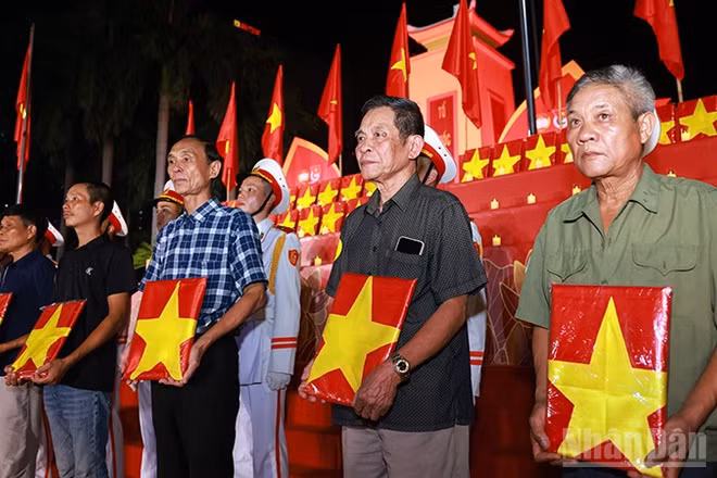 Đại diện gia đình, người thân liệt sĩ nhận di ảnh phục dựng tại buổi lễ. (Ảnh: Văn Tuyến)