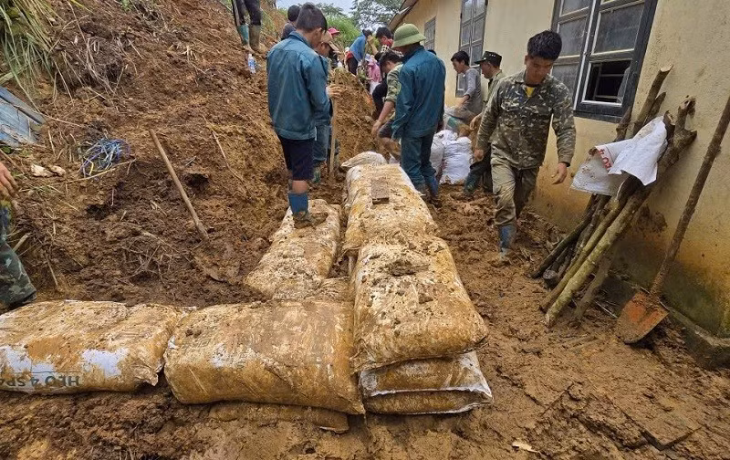 Cán bộ, chiến sĩ Ban Chỉ huy Bộ đội Biên phòng tỉnh Điện Biên hót đất, thông đường vào vùng lũ quét. 