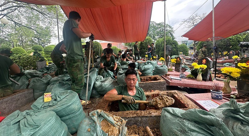 Cán bộ chiến sĩ Tổ 1 và Tổ 2 Bộ Chỉ huy quân sự tỉnh Điện Biên đang nỗ lực khai quật, lấy mẫu hài cốt liệt sĩ tại Nghĩa trang liệt sĩ Độc Lập. (Ảnh: LÊ LAN)