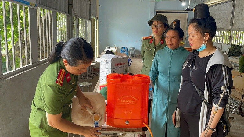 Hội viên phụ nữ Công an tỉnh Điện Biên hướng dẫn người dân cách khử khuẩn bằng chế phẩm sinh học. 
