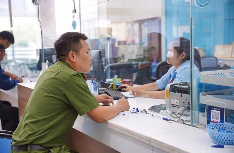Thiếu tá Lò Văn Dũng làm thủ tục xác minh, chuyển hoàn số tiền cho người đã chuyển nhầm. Ảnh: ANH TUẤN