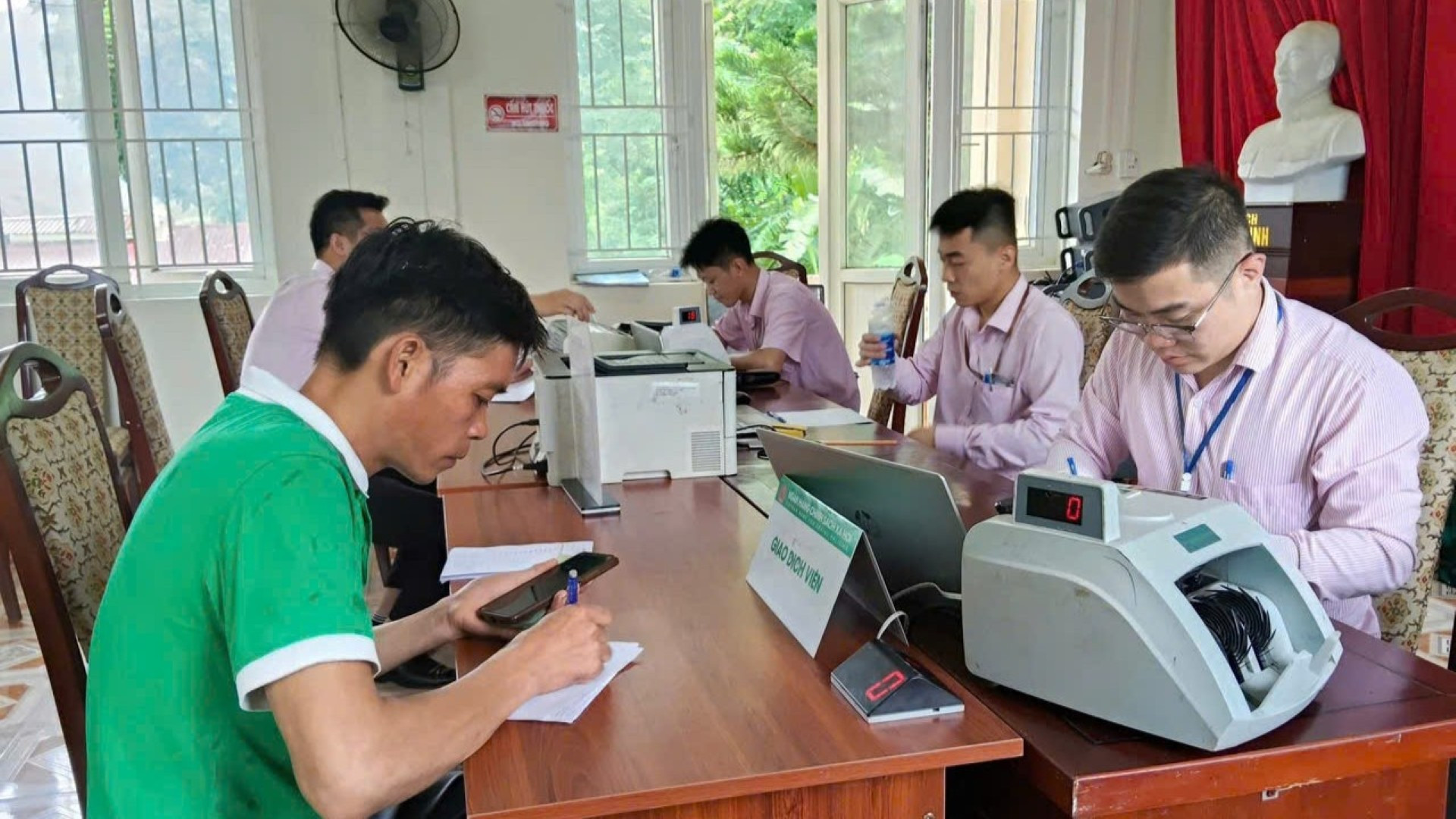 Cán bộ Ngân hàng Chính sách xã hội giao dịch với khách hàng. nhcsxh-giao-dich-khach-hang.jpg