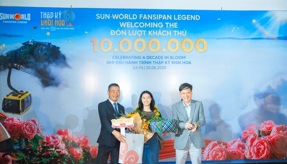 Ông Phạm Cao Vỹ - Chủ tịch Hiệp hội Du lịch tỉnh Lào Cai (bên trái) trao quà tặng cho vị khách thứ 10 triệu.