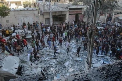 Người dân Palestine đứng giữa đống đổ nát của những tòa nhà bị phá hủy sau đòn không kích của Israel tại khu vực Al-Rimal, phía tây thành phố Gaza ngày 30/8/2025. (Ảnh: THX/TTXVN) 