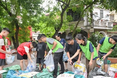 Các thành viên nhóm Tagom ở Hà Nội hướng dẫn người dân cách phân loại rác. (Ảnh THẾ ĐẠI)
