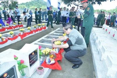 Thủ tướng Chính phủ Phạm Minh Chính thắp hương tại các phần mộ liệt sĩ mới an táng tại buổi lễ. (Ảnh: THANH GIANG) 
