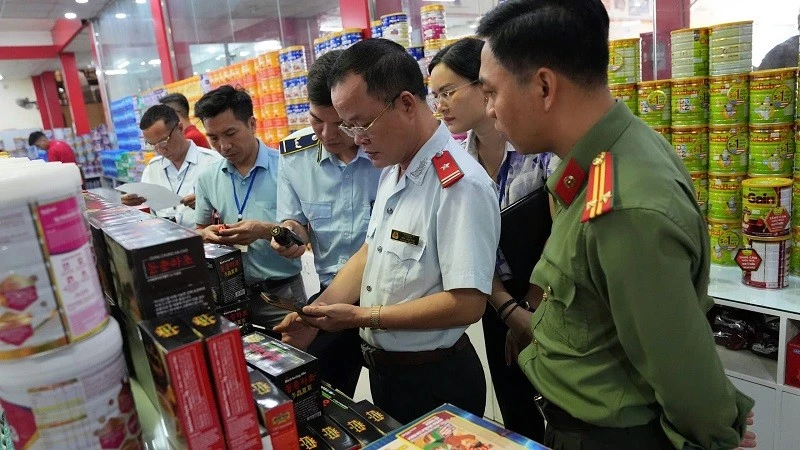 Lực lượng chức năng phối hợp kiểm tra hàng hóa là thực phẩm, sữa, thuốc tại các quầy hàng trung tâm thành phố Điện Biên Phủ. 