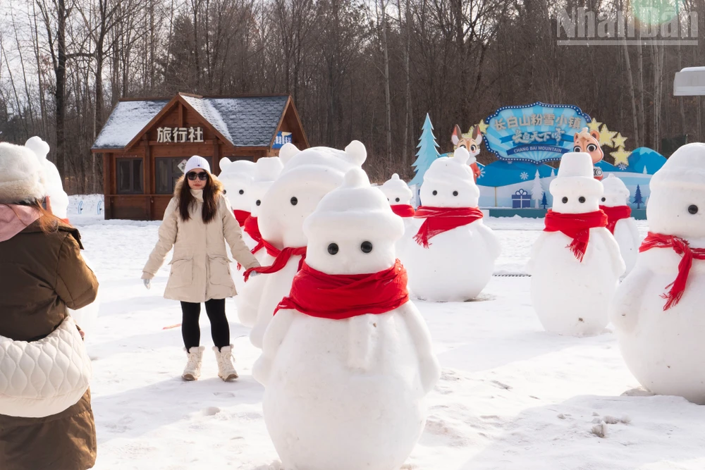 Du khách chụp ảnh check-in với người tuyết bên ngoài ga tàu cao tốc Trường Bạch Sơn.