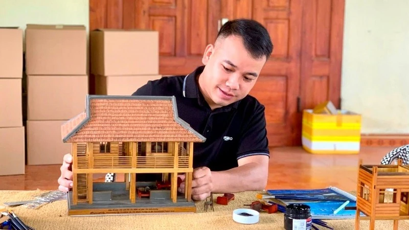 Luong Ngoc Tu works on a model of President Ho Chi Minh’s stilt house. (Photo courtesy of Tu)
