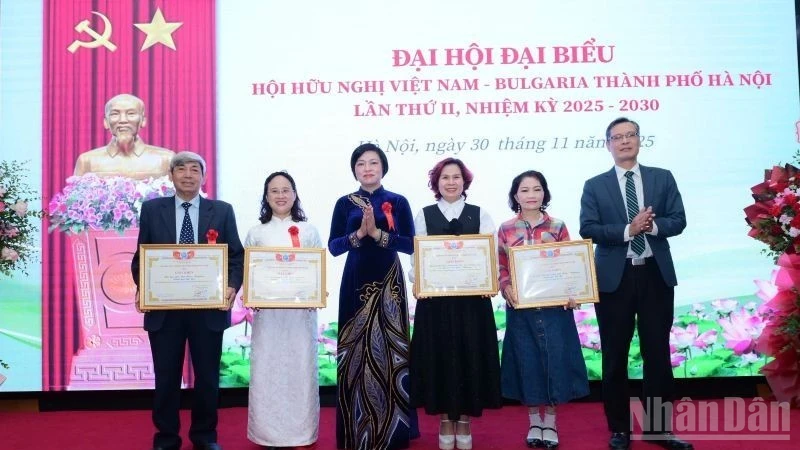 Tran Thi Phuong, Permanent Vice Chairwoman of the Ha Noi Union of Friendship Organisations, presents Certificates of Merit to individuals and collectives with outstanding contributions during the past tenure.