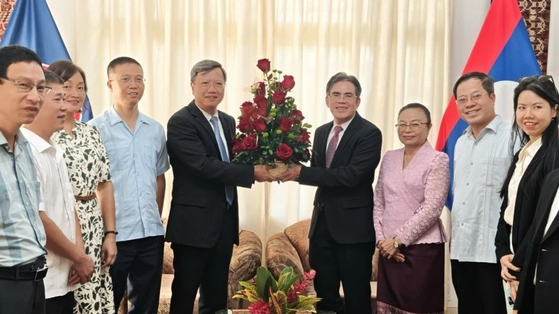 El embajador vietnamita Le Quang Long entrega flores a su similar de Laos, Vanhtha Sengmeuang. (Foto: Embajada de Vietnam en Cuba)