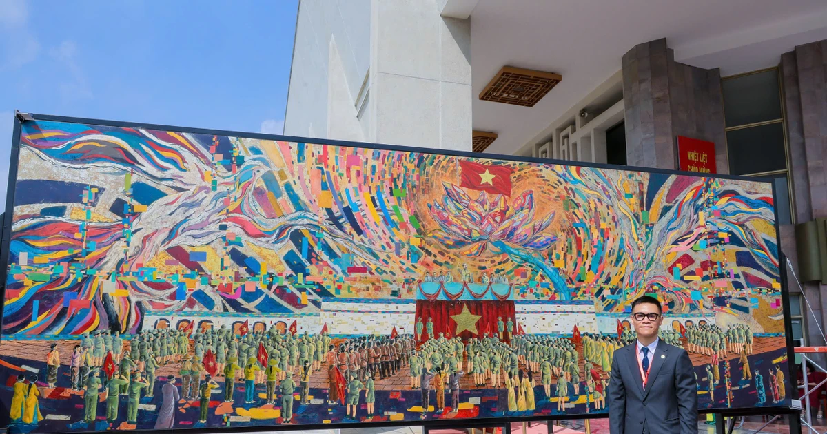 Artist Chu Nhat Quang beside his monumental lacquer painting “President Ho Chi Minh Reading the Declaration of Independence.”