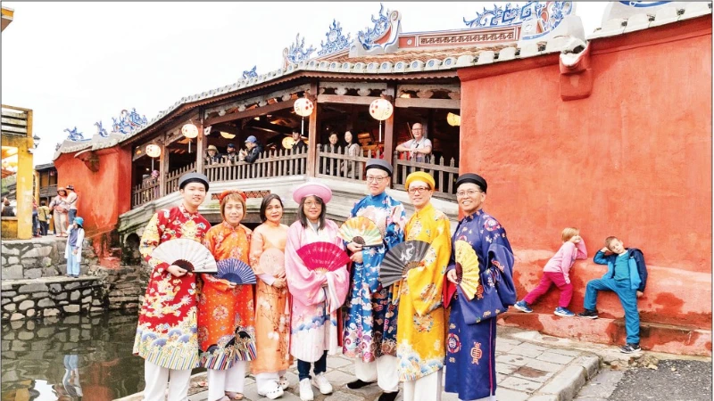 Visitors wearing Vietnamese traditional attire while exploring Hoi An Ancient Town (Da Nang).