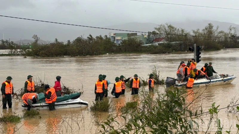 Rescue canoes cut through fast-flowing floodwaters in wind and rain to reach isolated residential areas.