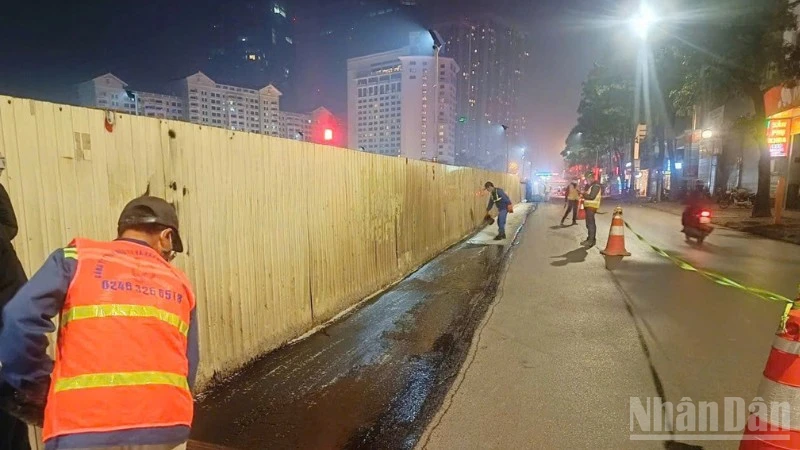 Công nhân thảm lại mặt đường sau khi dỡ bỏ phần quây tôn để trả lại mặt đường cho người tham gia giao thông.
