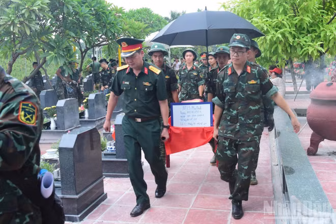Hài cốt liệt sĩ chưa xác định danh tính tại Nghĩa trang Mai Dịch (phường Phú Diễn) được cán bộ, chiến sĩ vận chuyển đến khu lấy mẫu. (Ảnh: HỮU THU)