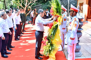 Thủ tướng Lê Minh Hưng chỉnh hoa trước khi vào dâng hương, dâng hoa tưởng niệm các Anh hùng liệt sĩ ở Khu di tích quốc gia đặc biệt hang Tám thanh niên xung phong. (Ảnh: Thanh Giang)