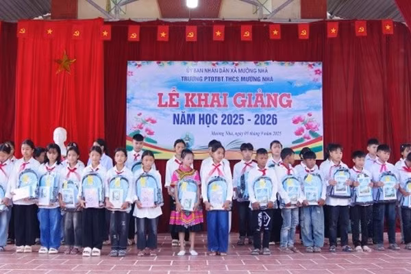 Cán bộ Đồn Biên phòng Cửa khẩu Huổi Puốc và Mường Nhà tặng quà tặng học sinh trong Dự án “Cán bộ, chiến sĩ Quân đội nâng bước em tới trường”. (Ảnh: ANH DŨNG)