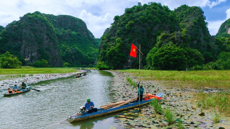 អ្នកបើកទូកបានភ្ជាប់ទង់ជាតិនីមួយៗយ៉ាងល្អិតល្អន់ទៅនឹងទូកនីមួយៗ និងតាមផ្លូវទៅកាន់តំបន់ទេសចរណ៍ Tam Coc។ img-2193-3731.jpg