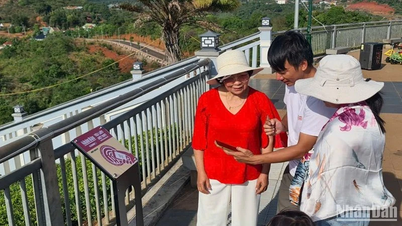 Hướng dẫn du khách thực hiện các thao tác check in trên bảng gắn chip NFC đặt tại thành phố Gia Nghĩa, tỉnh Đắk Nông.