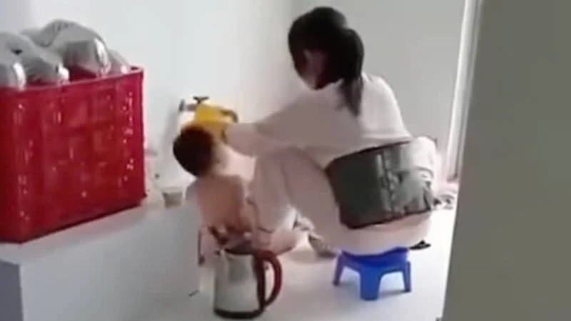 Nhân viên cơ sở nhóm, lớp mầm non Thu Sương đổ thức ăn vào miệng trẻ. (Ảnh: cắt từ clip)